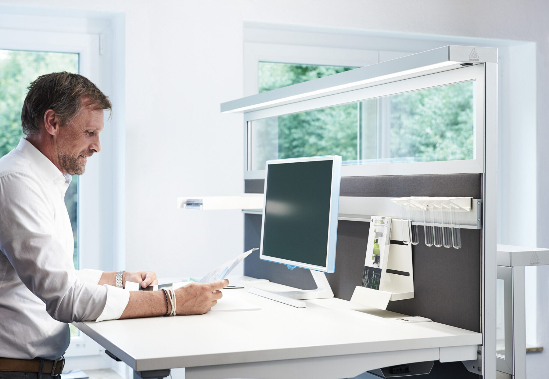 Schallschutz am Schreibtisch mit Schreibtischtrennwand und integrierter Arbeitsplatzbeleuchtung